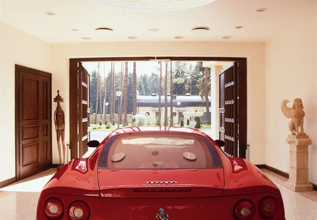 В гараже — стеклянная стена, которая позволяет из дома любоваться красной Ferrari, превращенной в элемент дизайна.